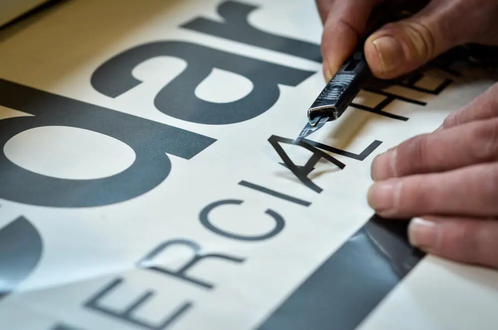 Hand-weeding cut vinyl lettering in the Three Sixty workshop