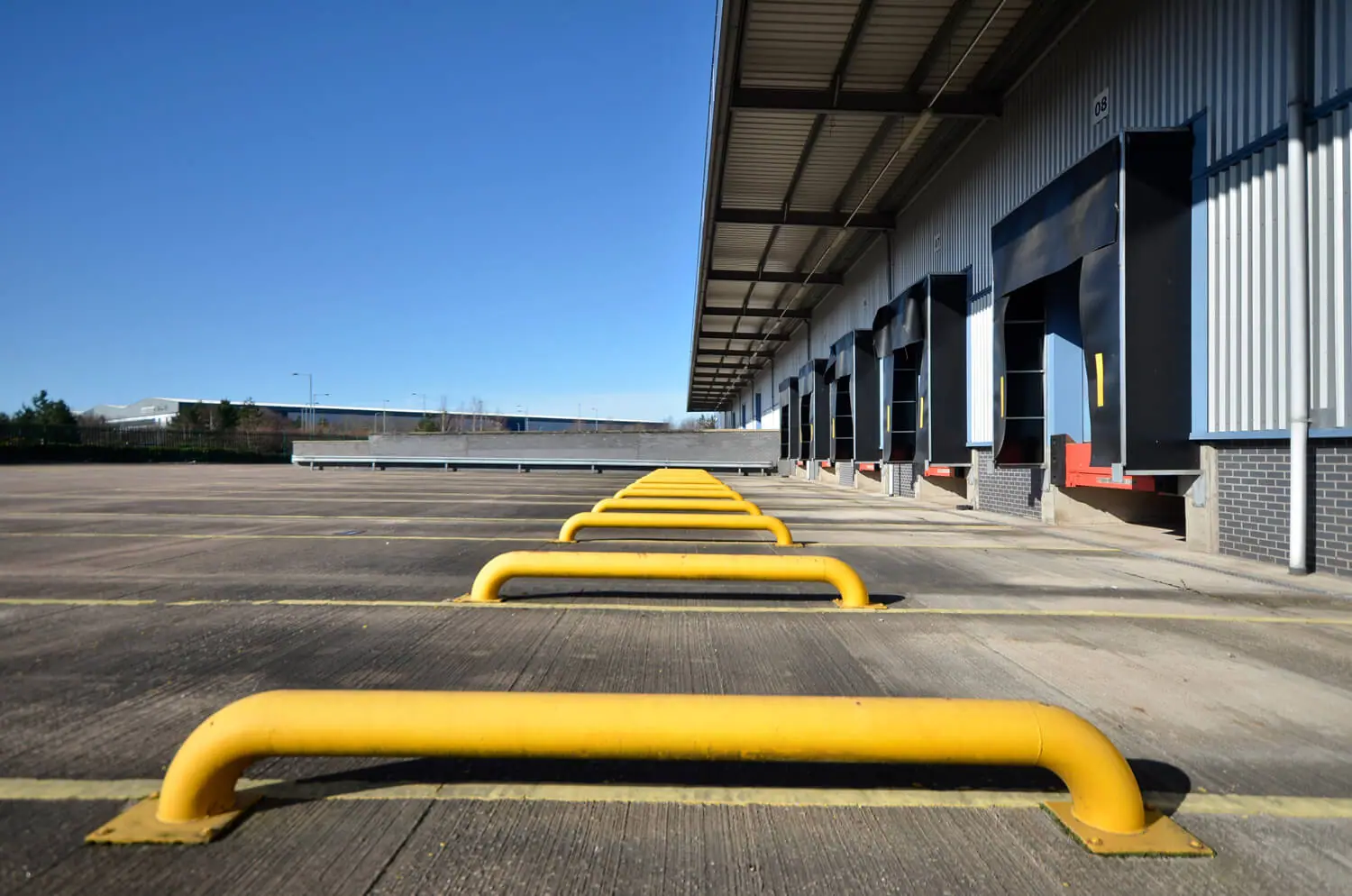 Yellow bollards at a warehouse loading bay