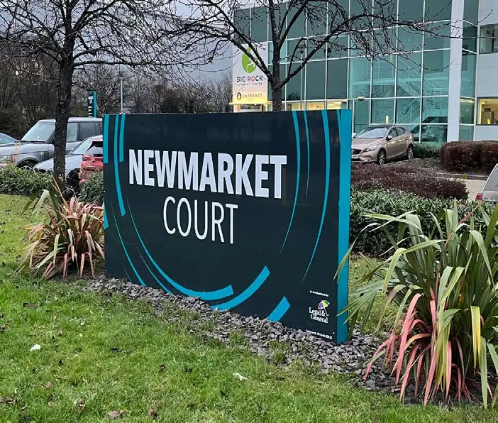 Newmarket Court estate sign in a planted bed