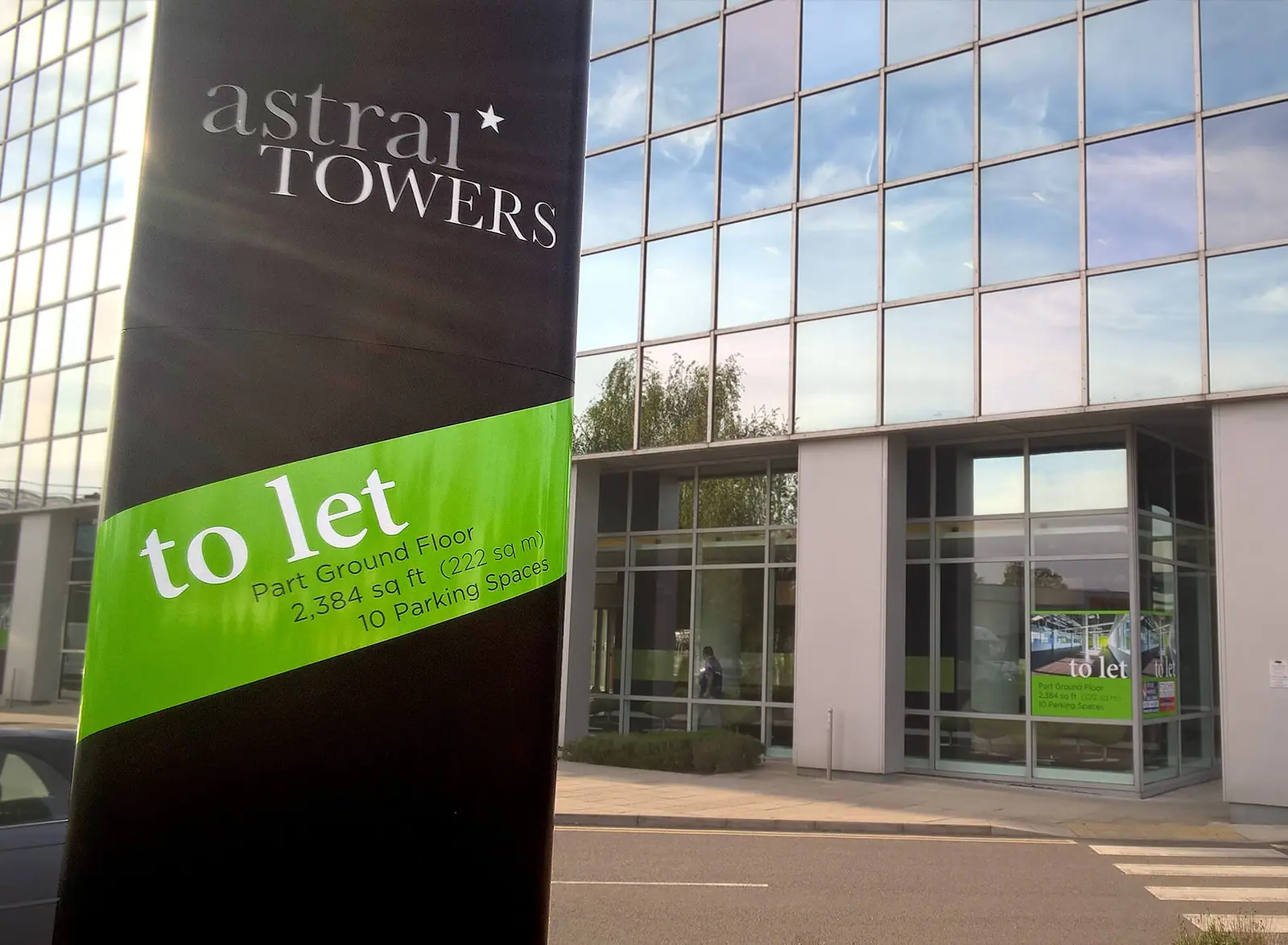 Astral Towers 'to let' totem with a lime-green panel outside the office building