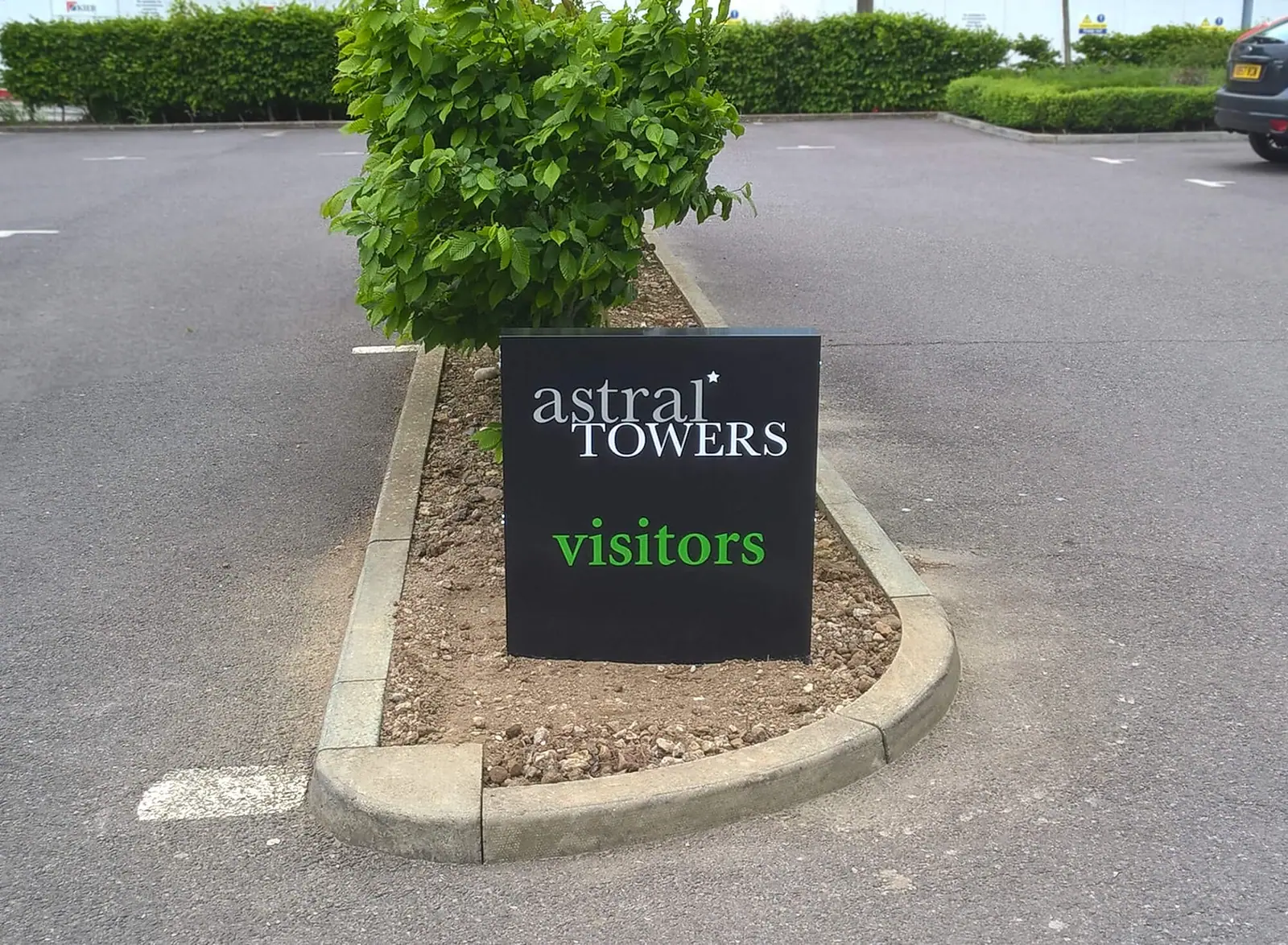 Astral Towers visitor parking sign set in planting