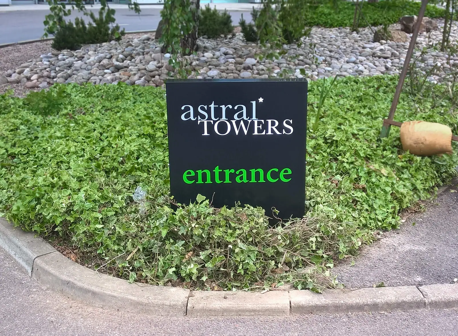 Astral Towers entrance sign in a landscaped bed