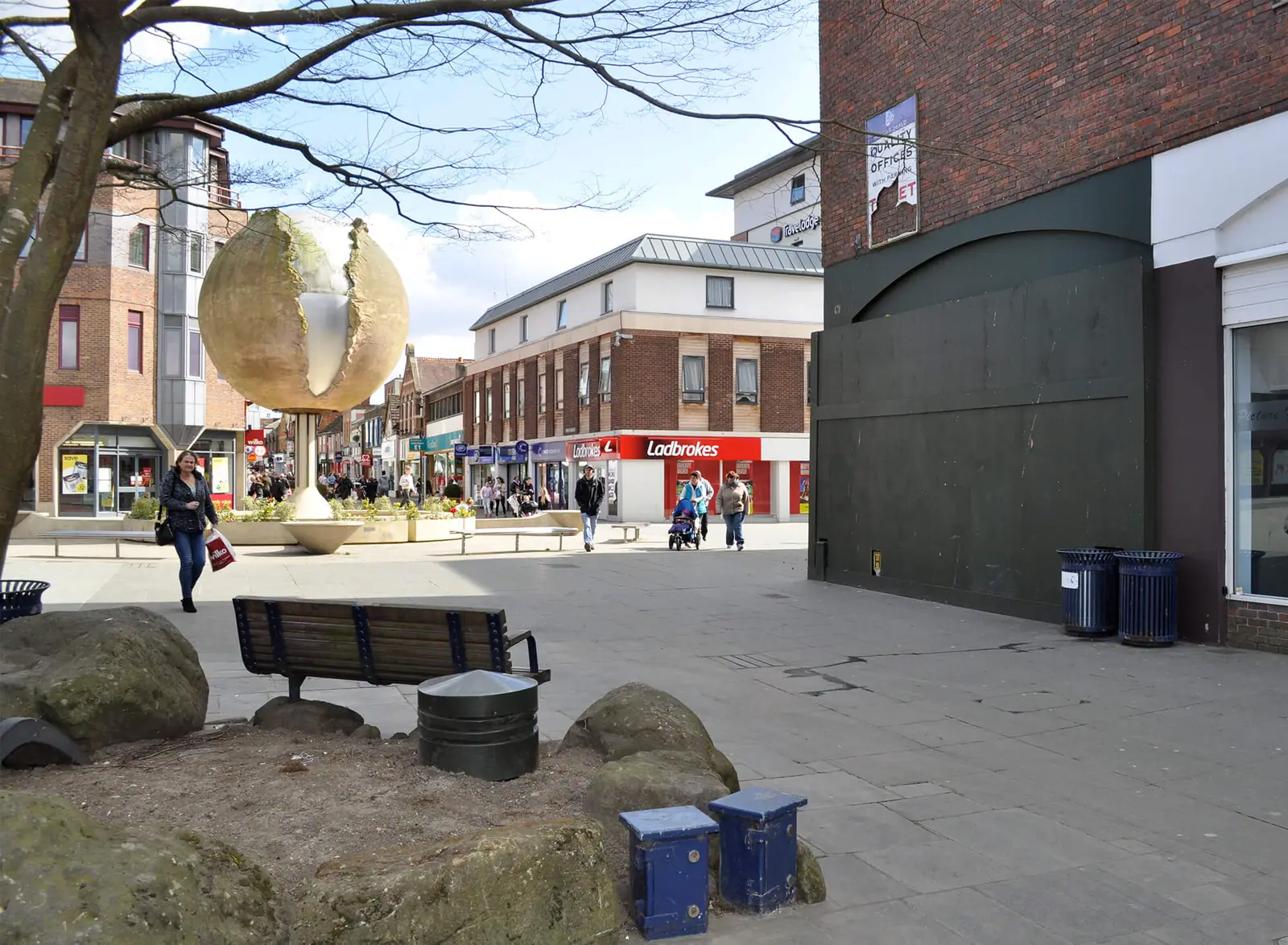 The square's sculpture and seating with shopfronts behind
