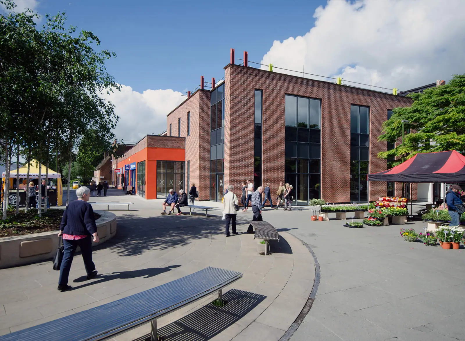 Shoppers passing the retail units on a sunny day