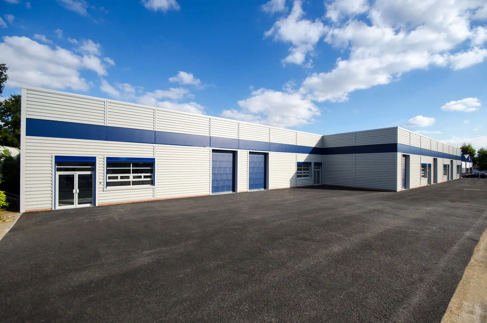 Terrace of refurbished industrial units with blue roller doors