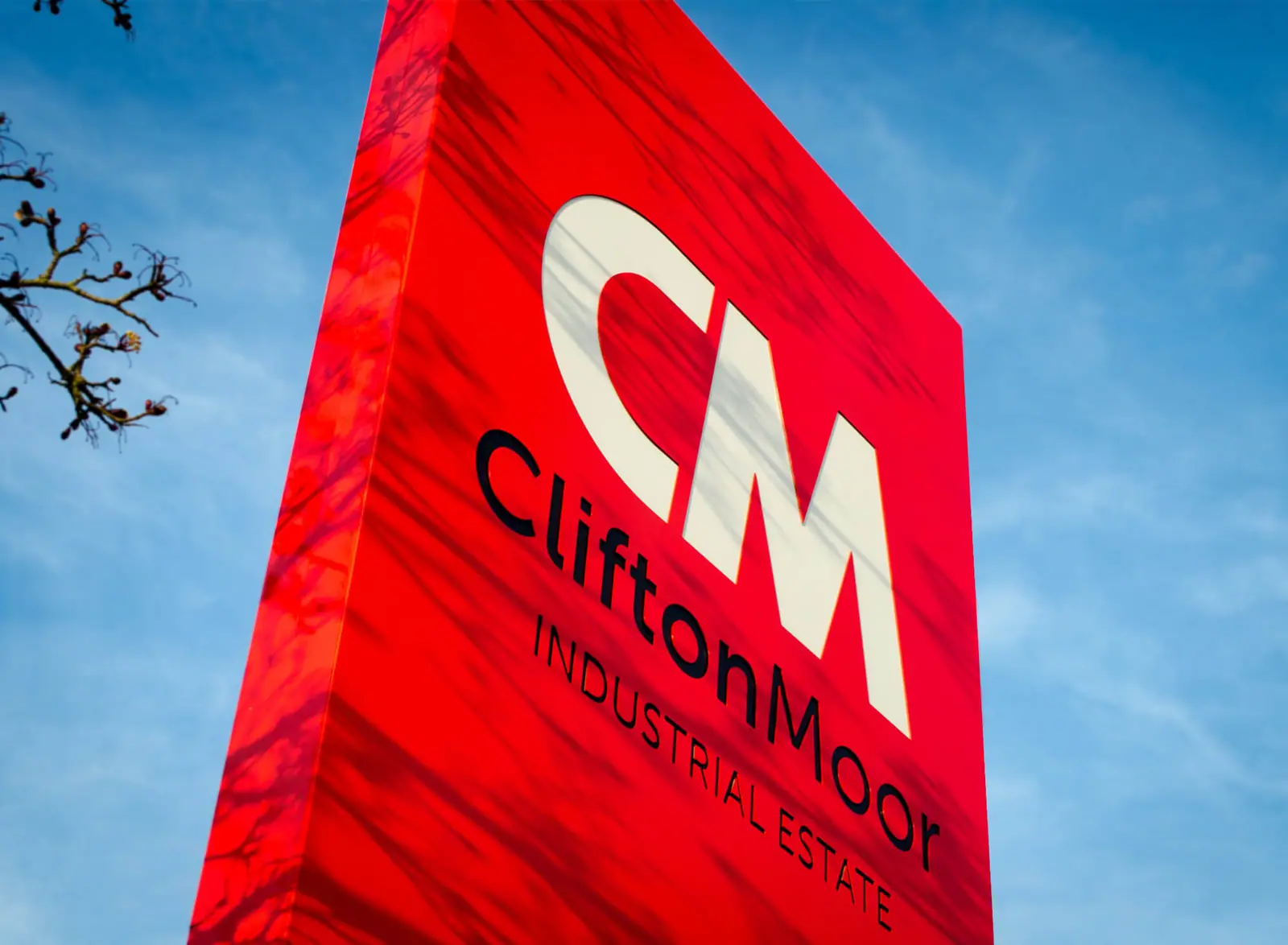 Bright red Clifton Moor estate totem with the CM monogram