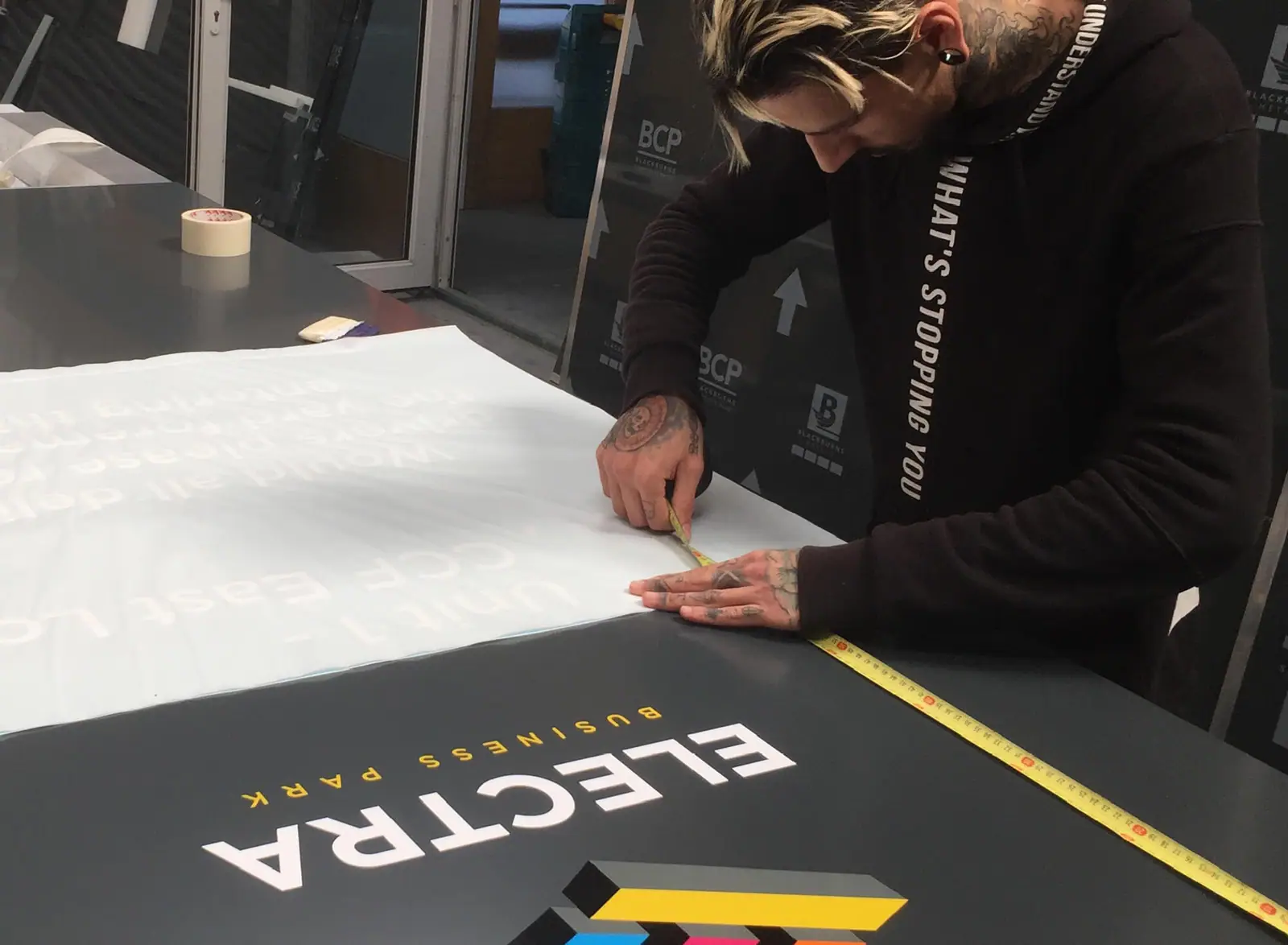 Designer weeding vinyl lettering for an Electra sign in the Three Sixty studio