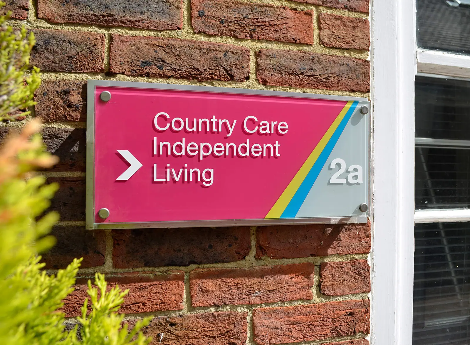 Magenta occupier plaque for unit 2a with the estate's rainbow stripe
