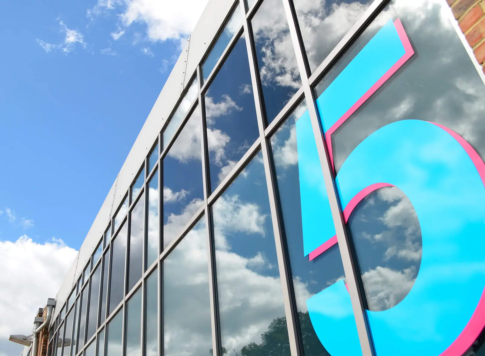 Large cyan vinyl building number 5 on the glazed facade