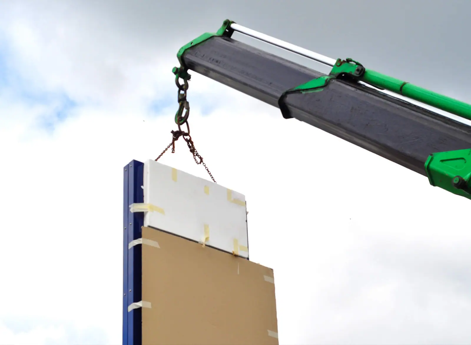 Hiab crane lowering the new totem into position
