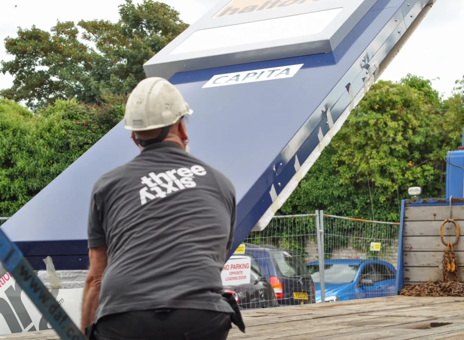 Three Sixty installers guiding the totem from the lorry