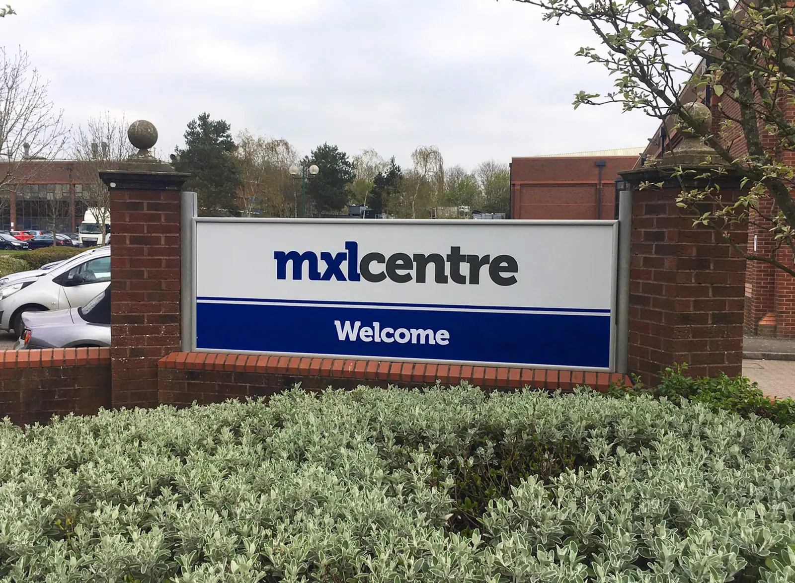 MXL Centre welcome sign in a brick wall
