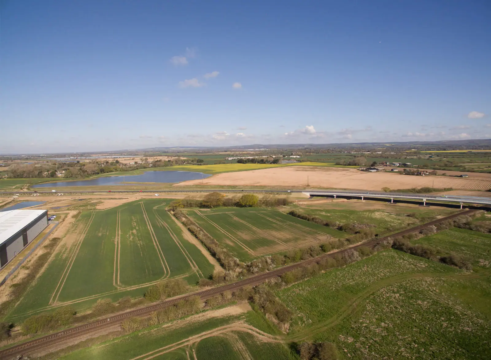 Wide aerial of farmland and the development site