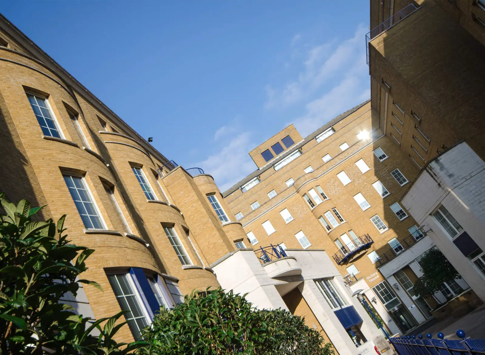 Trafalgar House facade in yellow brick against a blue sky