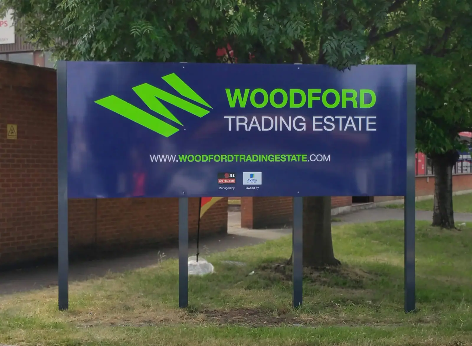 Woodford Trading Estate entrance sign in navy and lime